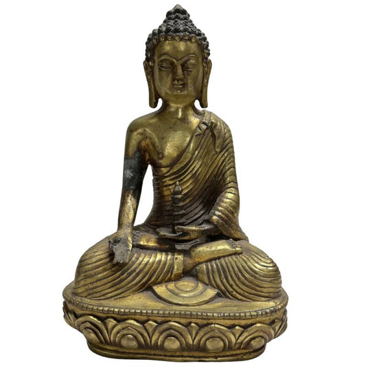 Gros plan sur la statue ancienne en bronze du Bouddha de la Médecine Bhaisajyaguru, assis en position du lotus, avec de subtils accents dorés sur le visage et le pot de médecine dans sa main gauche.