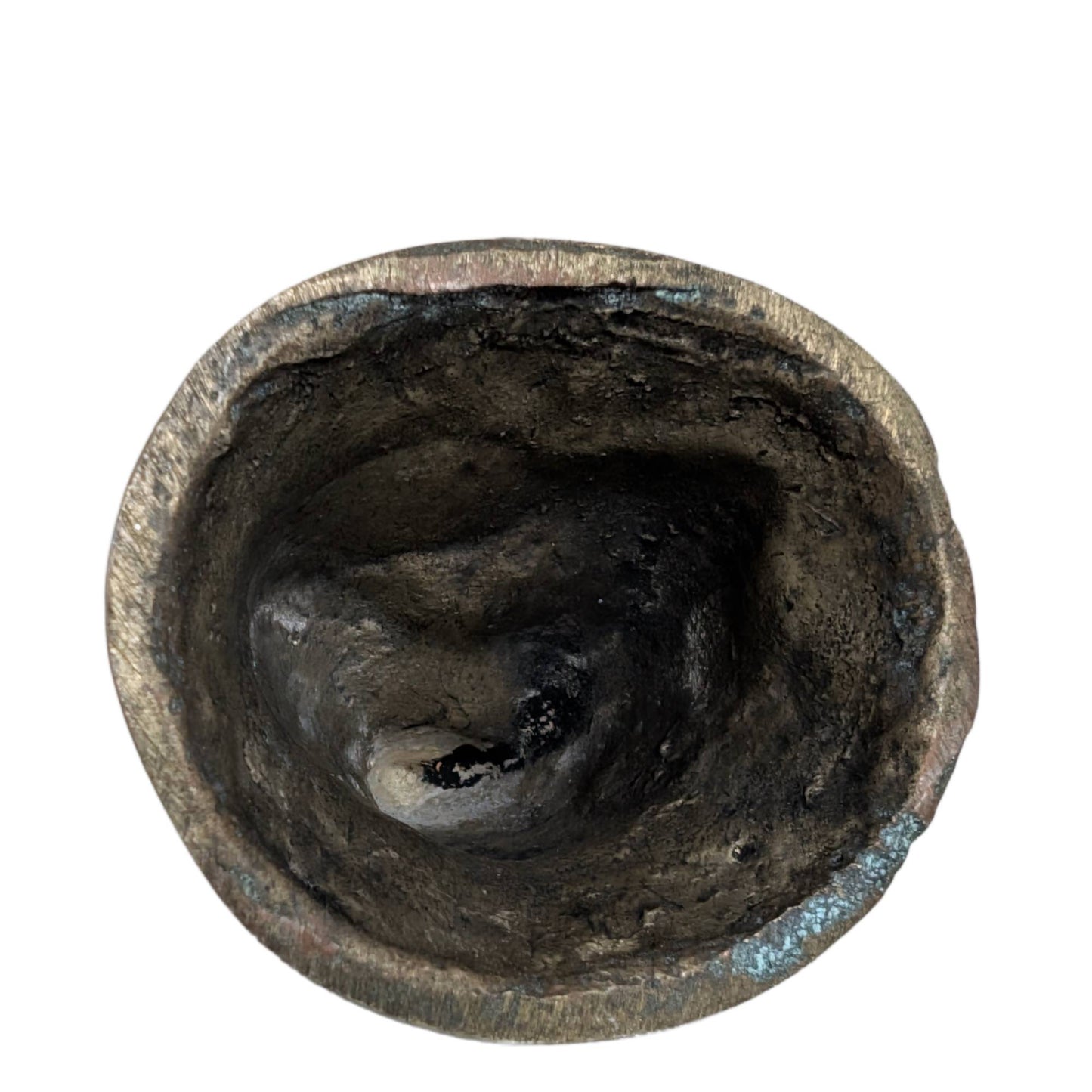 The hollow underside of the hand-cast brass Buddha figurine.