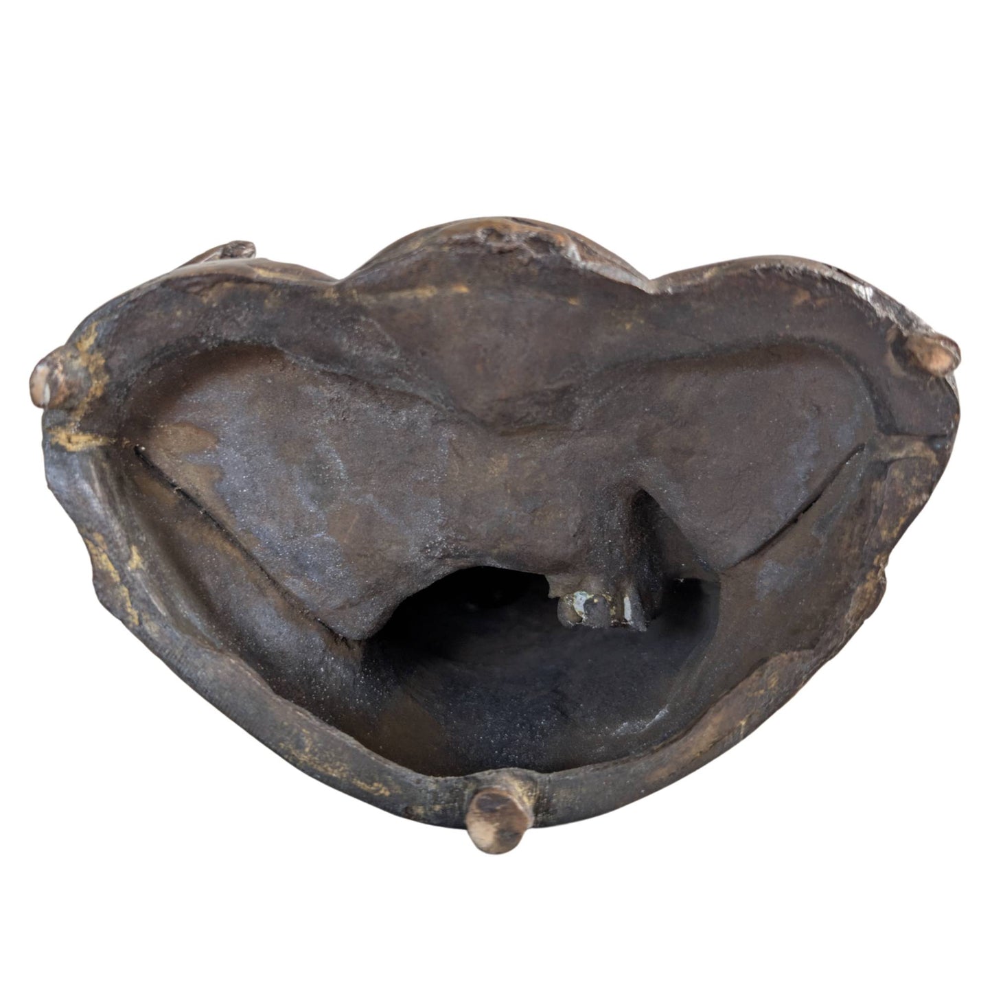 The underside of the heavy bronze statue with a visible hollow core from the casting process.