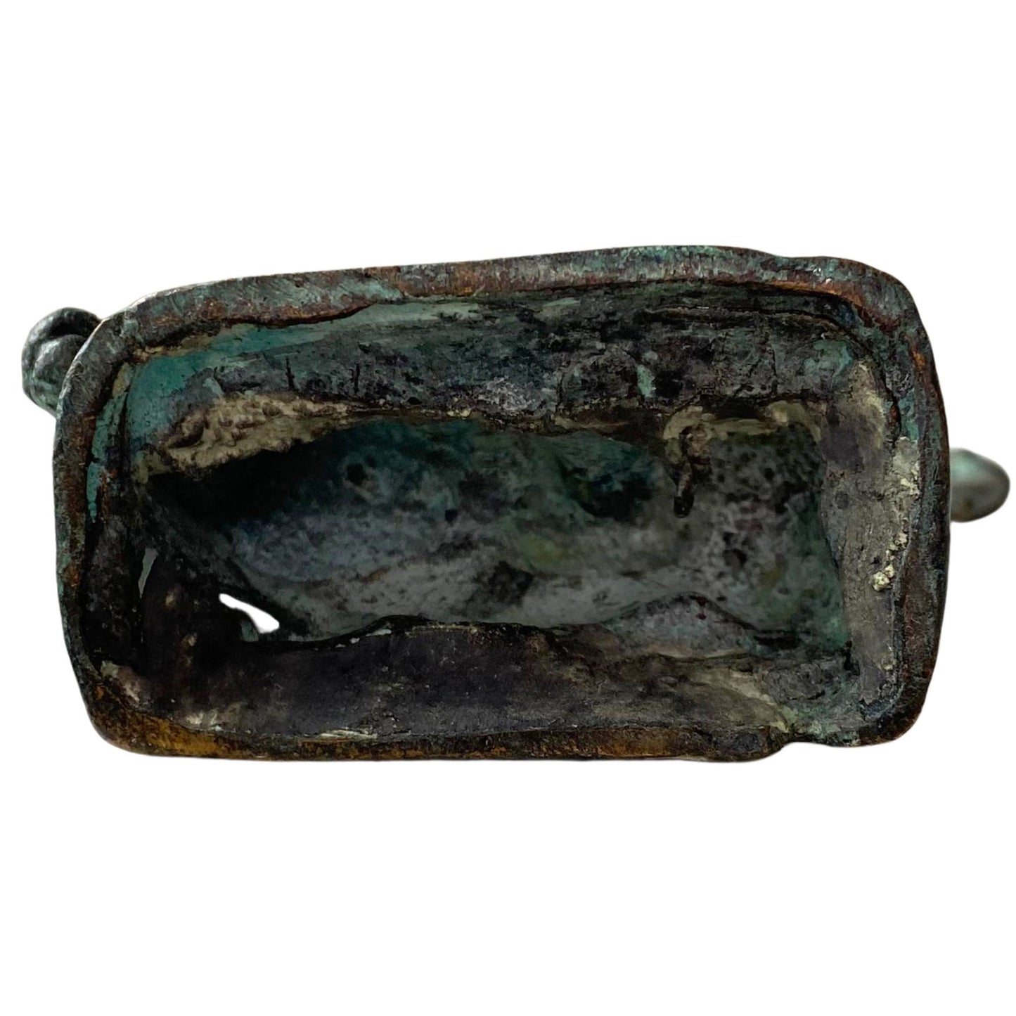 The hollow underside shows mineral calcification and a rough casting structure.