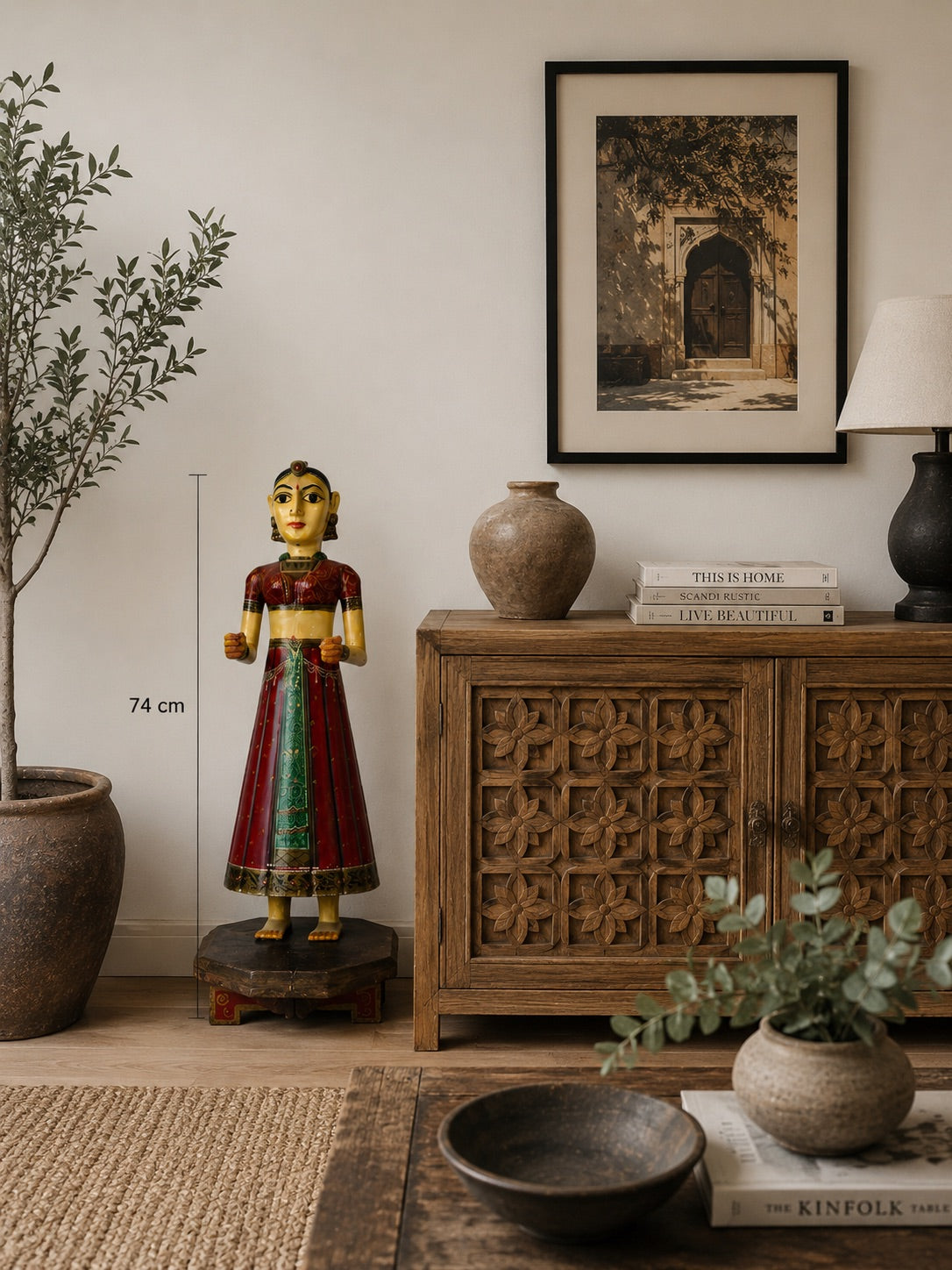 Detail of a Rajasthani bride statue with red, gold, and green painting on hand-carved wood