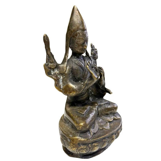 Detail of Manjushri iconography on an antique Tibetan lama statue with sword and book