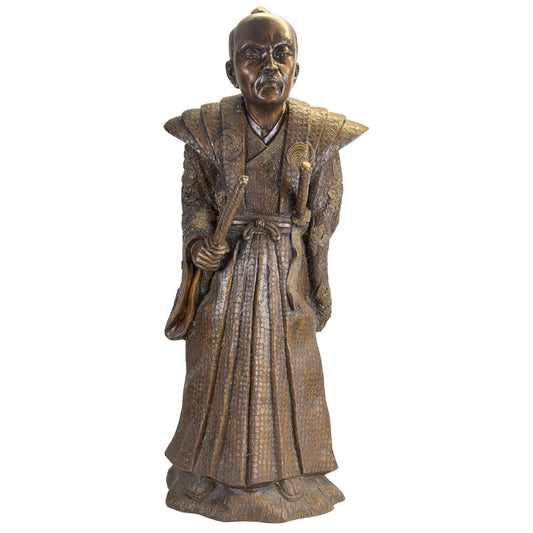 A historical Japanese bronze sculpture of a Samurai from the Meiji period displayed in a museum setting.