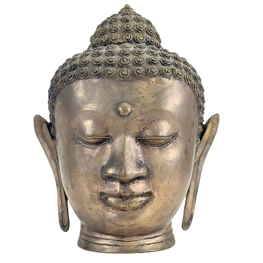 A historic Thai bronze Buddha head in Sukhothai style displayed in a museum setting.