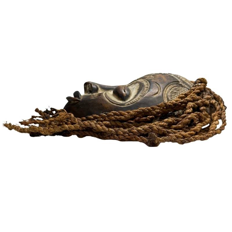 African dance mask with high comb-shaped headdress, open wooden structure and traditional ritual appearance and hair made of rope