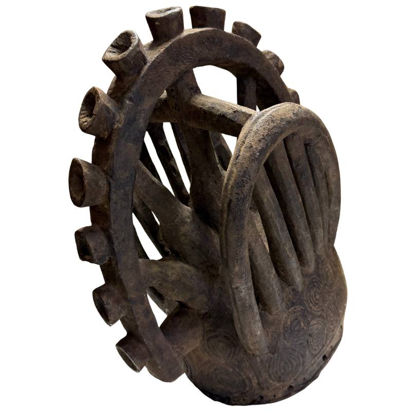 African mask with spiral patterns, old wooden ceremonial object with a weathered surface and characterful shape