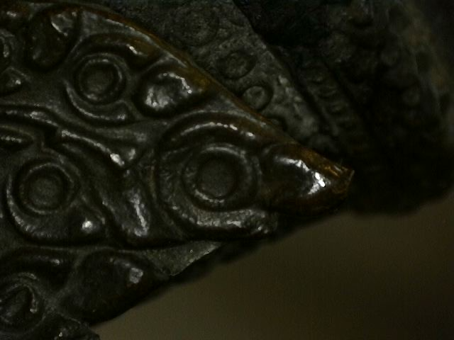 Microscope photo of aged bronze surface on Thai sculpture