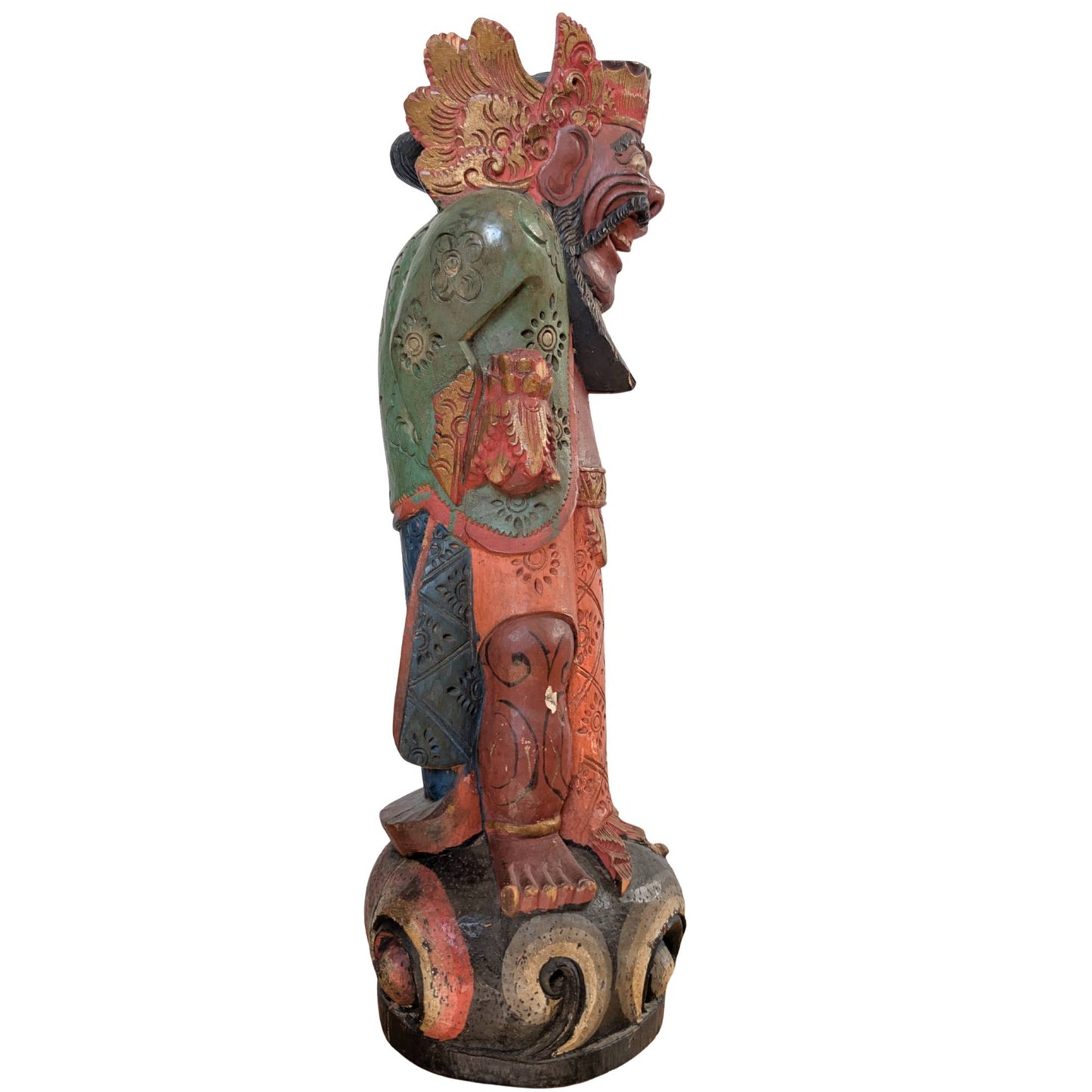 Side view of the wooden Balinese guardian figure on a stylized pedestal