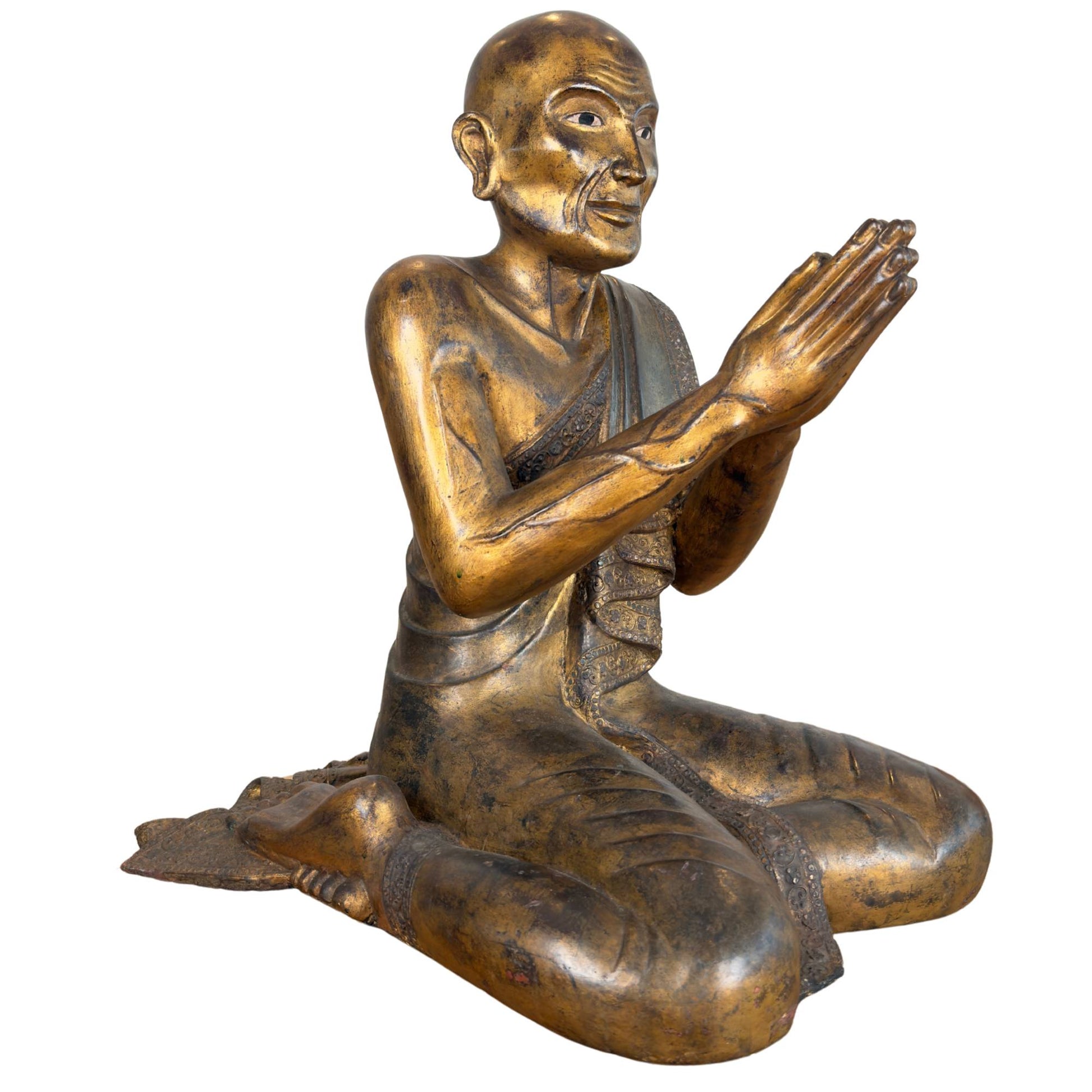 Burmese monk Moggallana of gilded wood seated in a devotional posture with carved veins on the arm and inlaid eye.