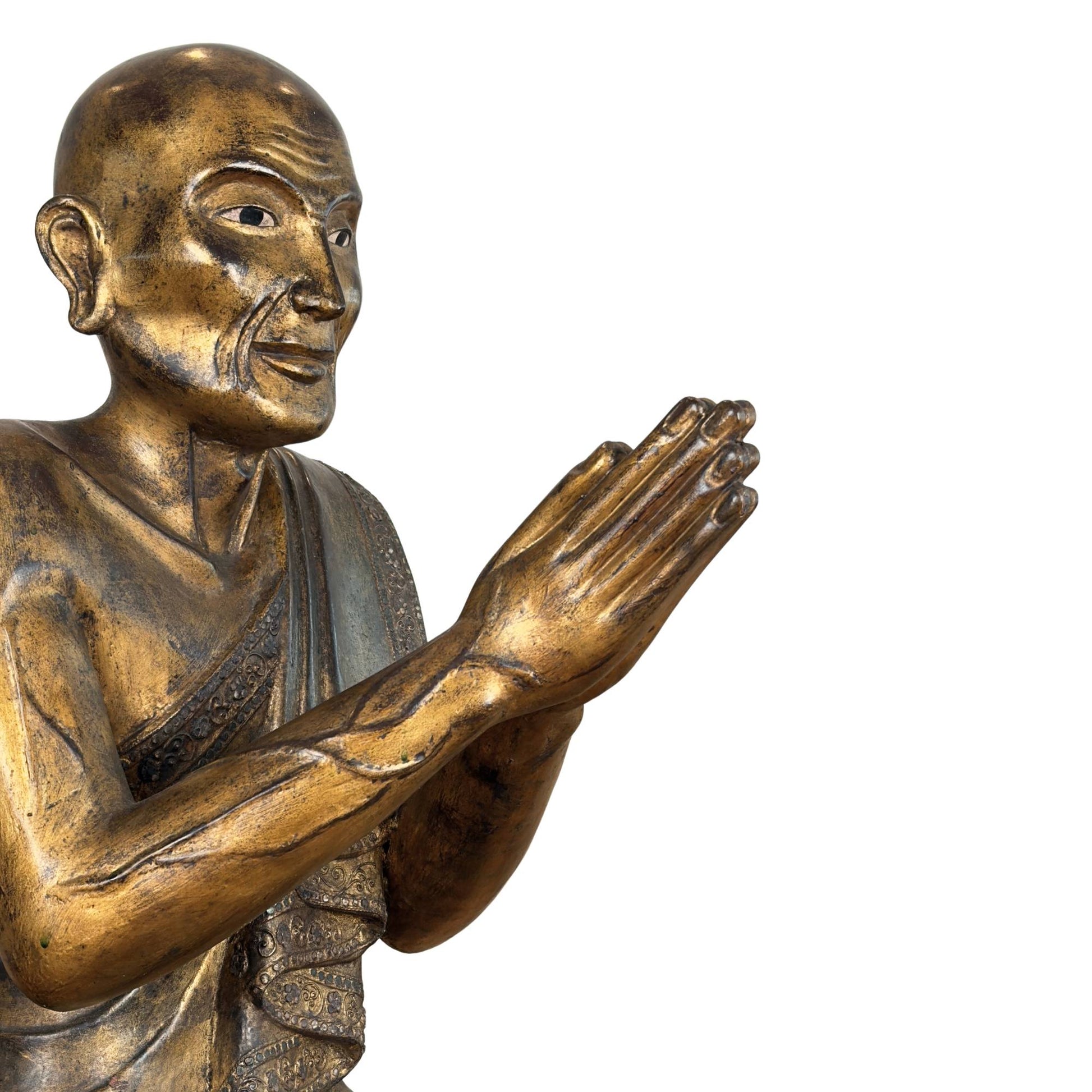 Burmese monk Sariputta of gilded wood with hands in Anjali mudra and pronounced veins on the forearm.