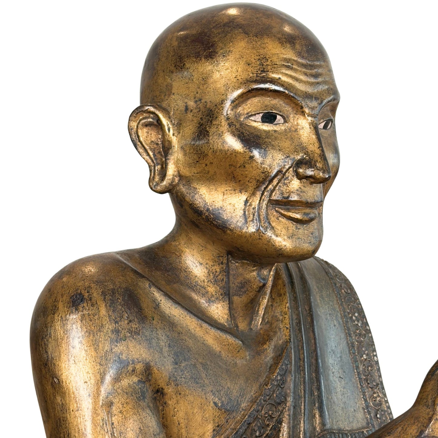 Burmese Sariputta monk of gilded wood with inlaid mirror glass eyes and deep hand-carved facial wrinkles.