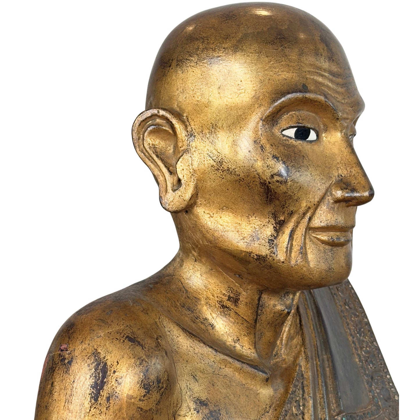 Skull and facial profile of the Burmese monk Sariputta of gilded wood with inlaid mirror glass eye and intense patina layers on the shoulder.