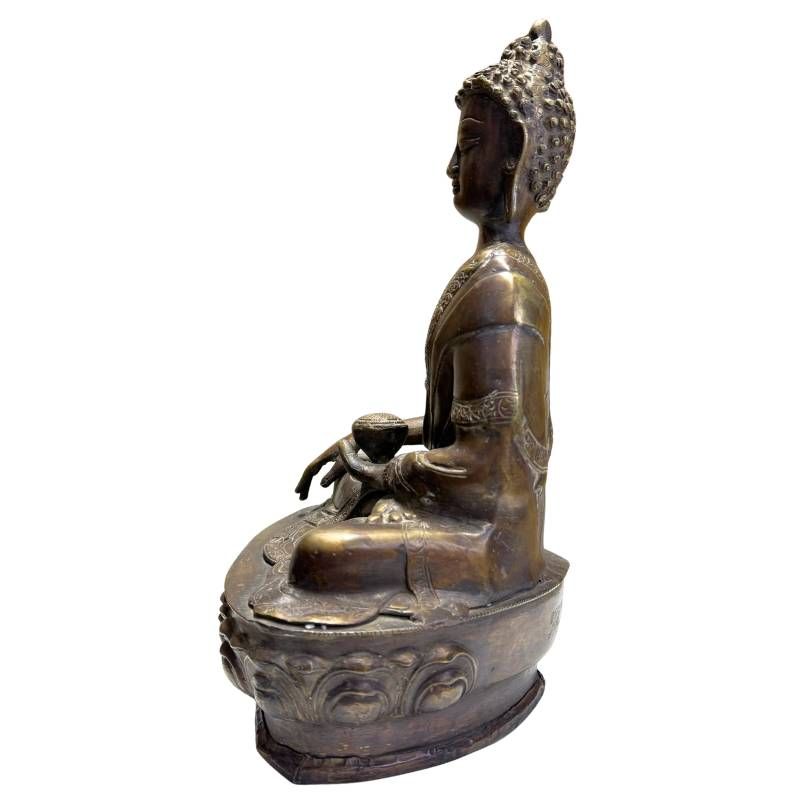 Detail of antique bronze Medicine Buddha with a calm expression