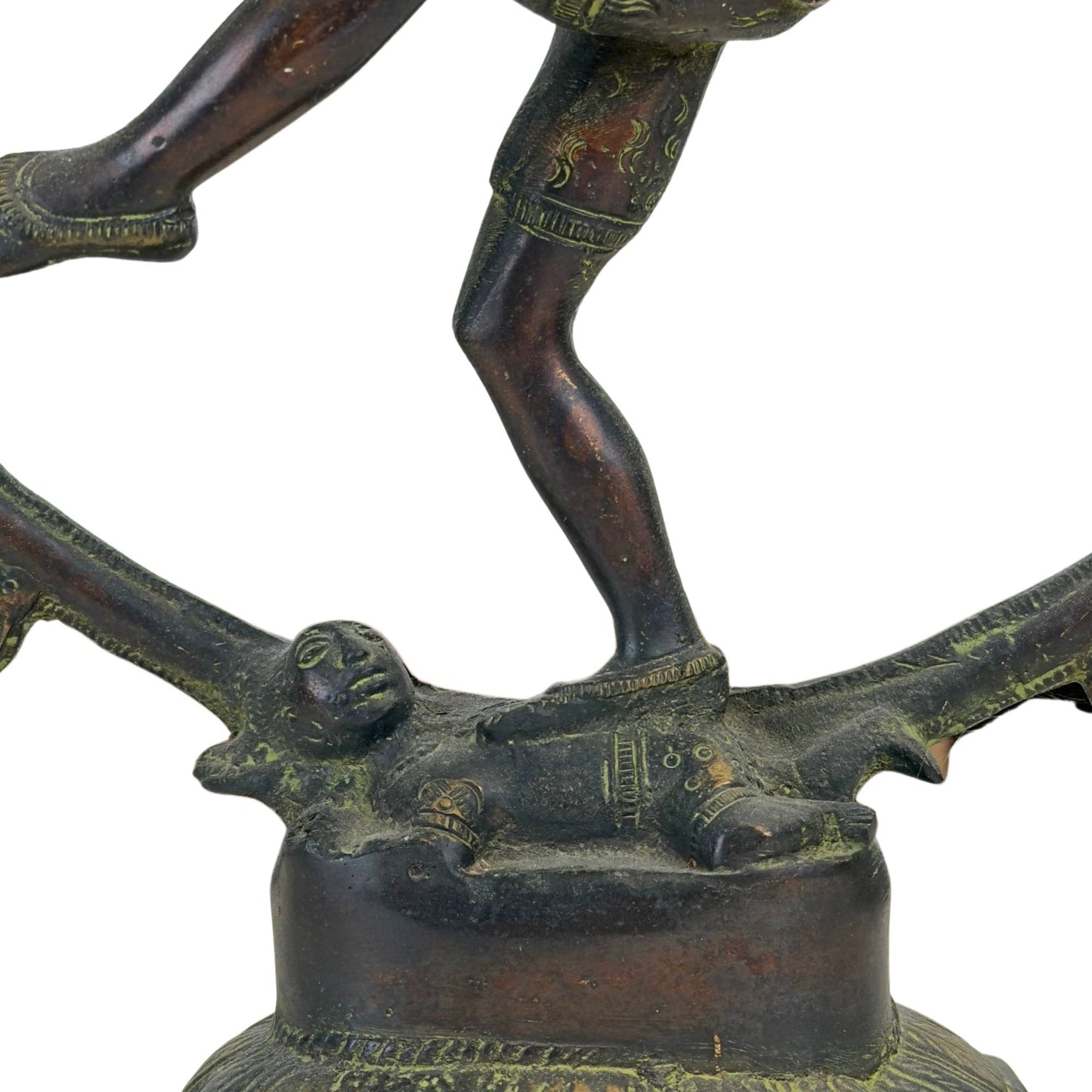 Detailopname van de dwerg Apasmara onder de voet van Shiva Nataraja op de bronzen lotusbasis