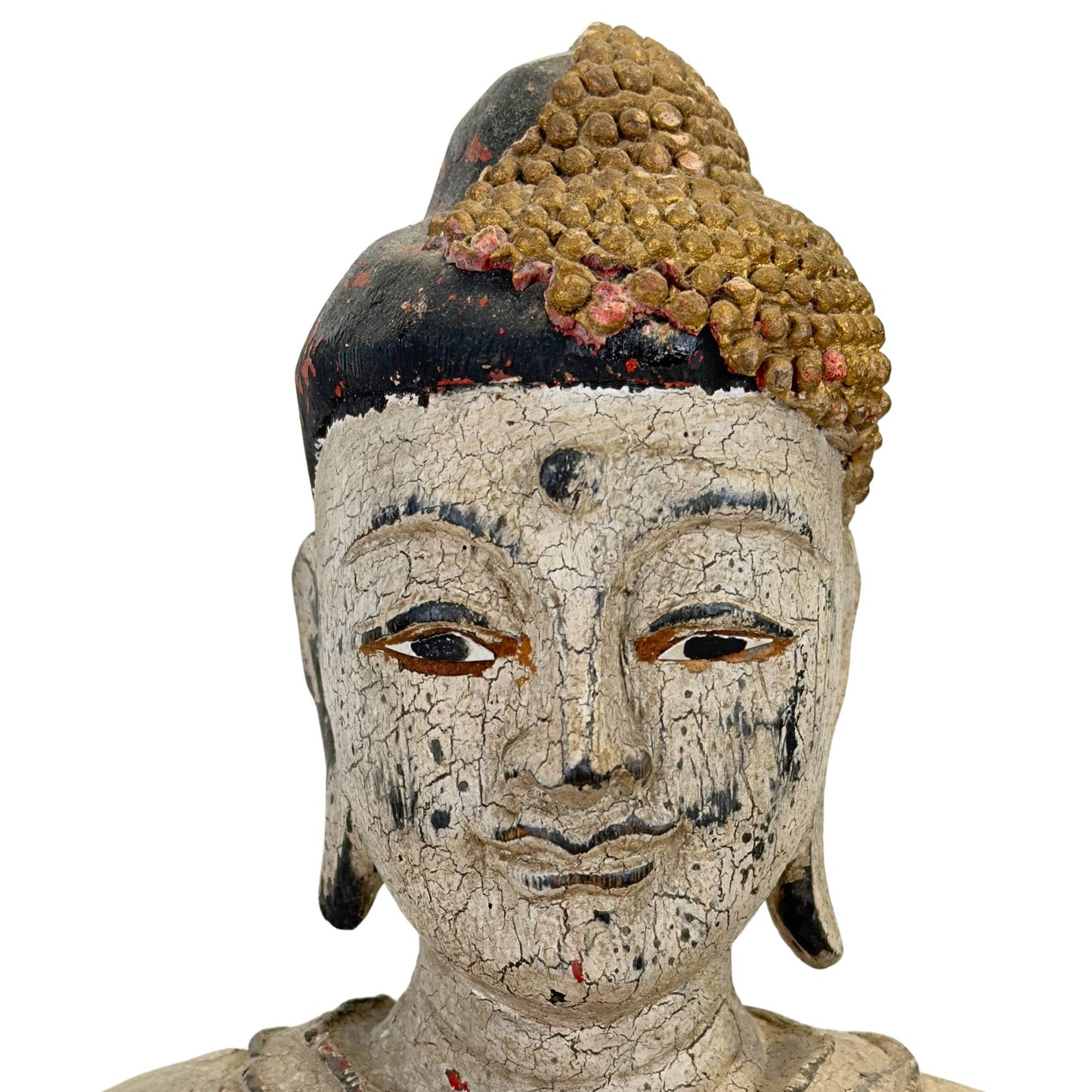 Gros plan frontal du visage à la peau épaisse, profondément craquelée et recouverte de gesso blanc, et à l'expression sereine.