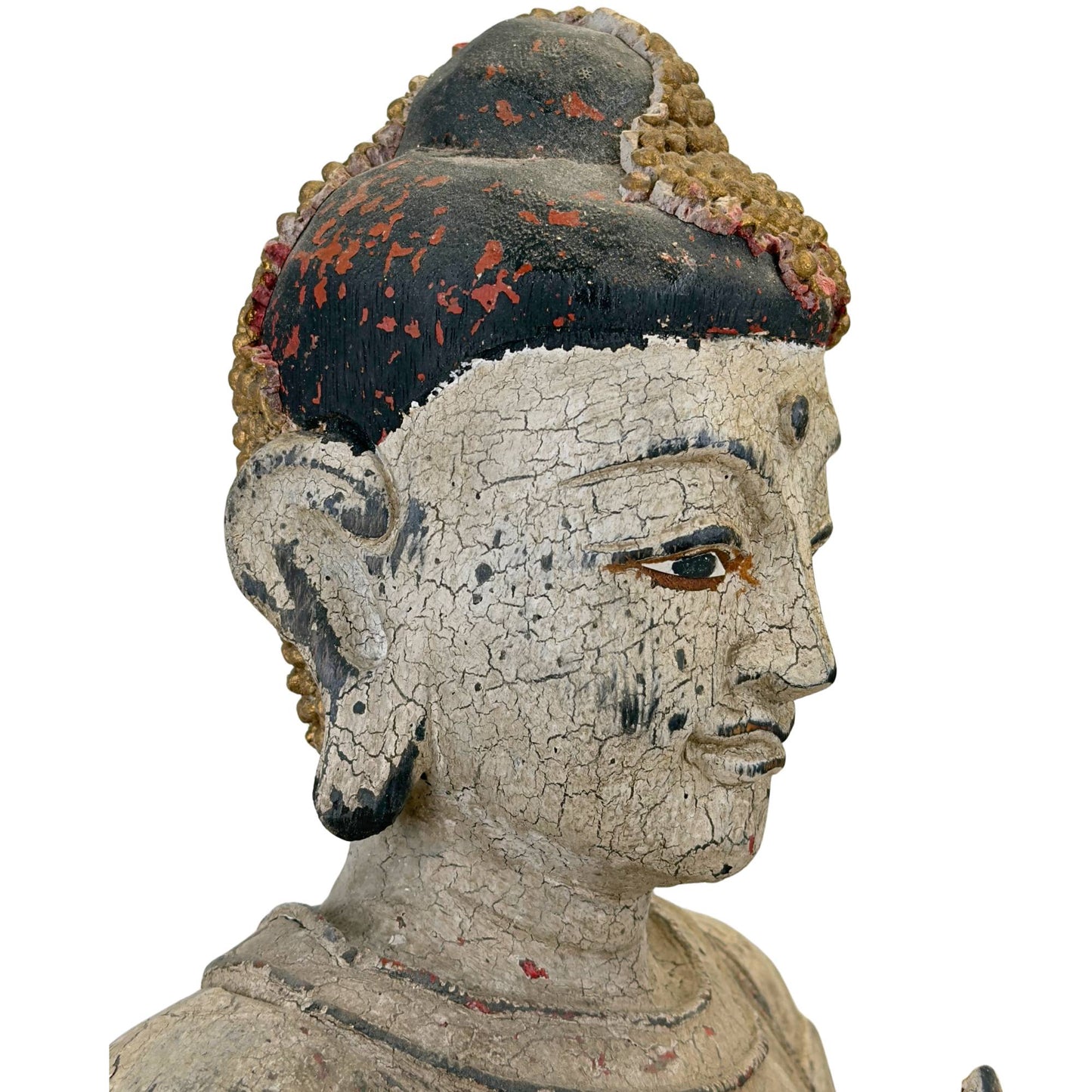 Vue de trois quarts de profil de la tête de Bouddha montrant la stratigraphie en couches des pigments anciens et le craquelé organique à la chaux.