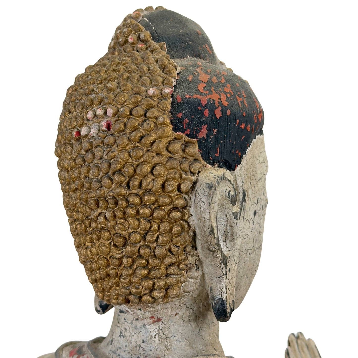 Gros plan sur l'arrière du crâne montrant l'érosion asymétrique des perles dorées ushnisha et le bois de teck foncé exposé.