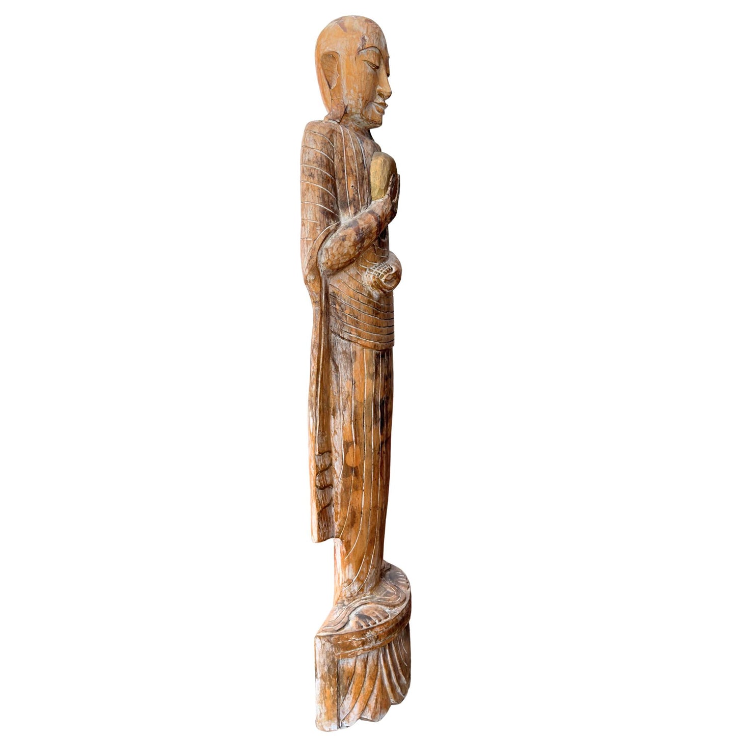Vue de profil élancée de la statue monumentale d'un moine bouddhiste à la structure en bois Wabi Sabi brute et pure