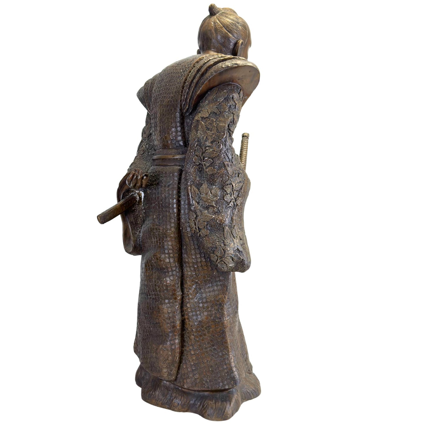 Slanted back of the bronze Meiji statue showing the floral high relief on the sleeves and the flowing folds.