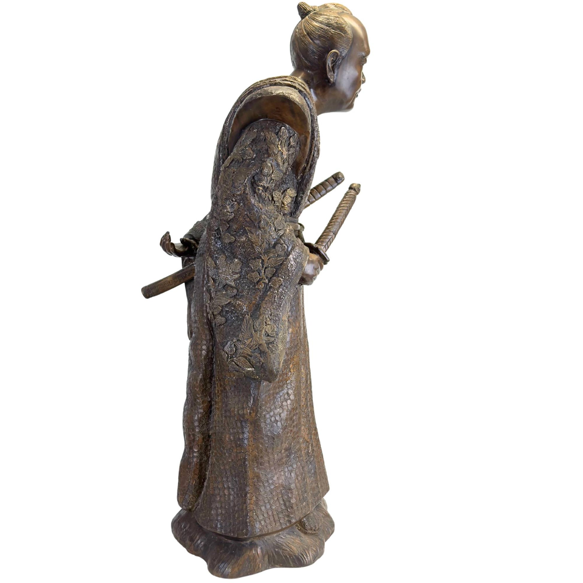 Close-up of the sword hilts of the Katana and Wakizashi tucked into the Obi belt of the bronze statue.