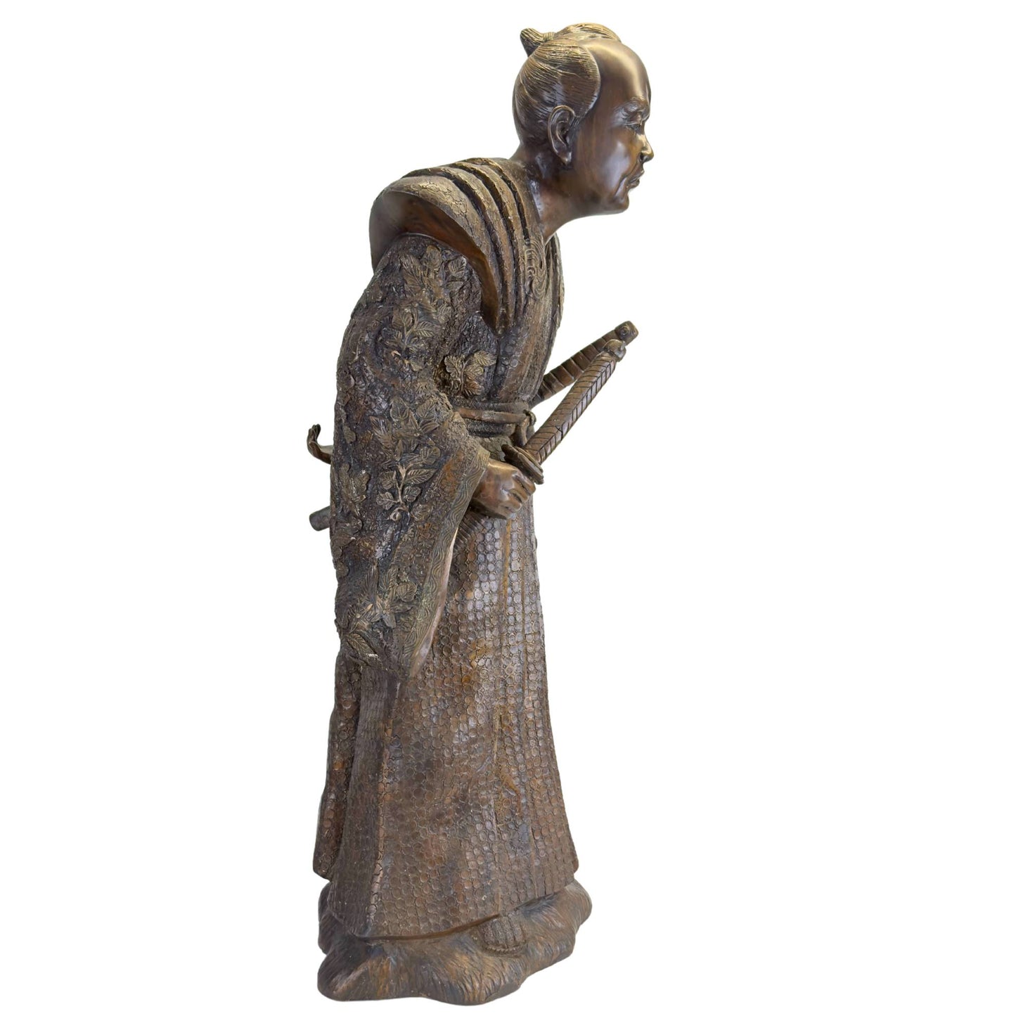 Close-up of the expressive face with an intense gaze and traditional chonmage hairstyle of the bronze Meiji Samurai.