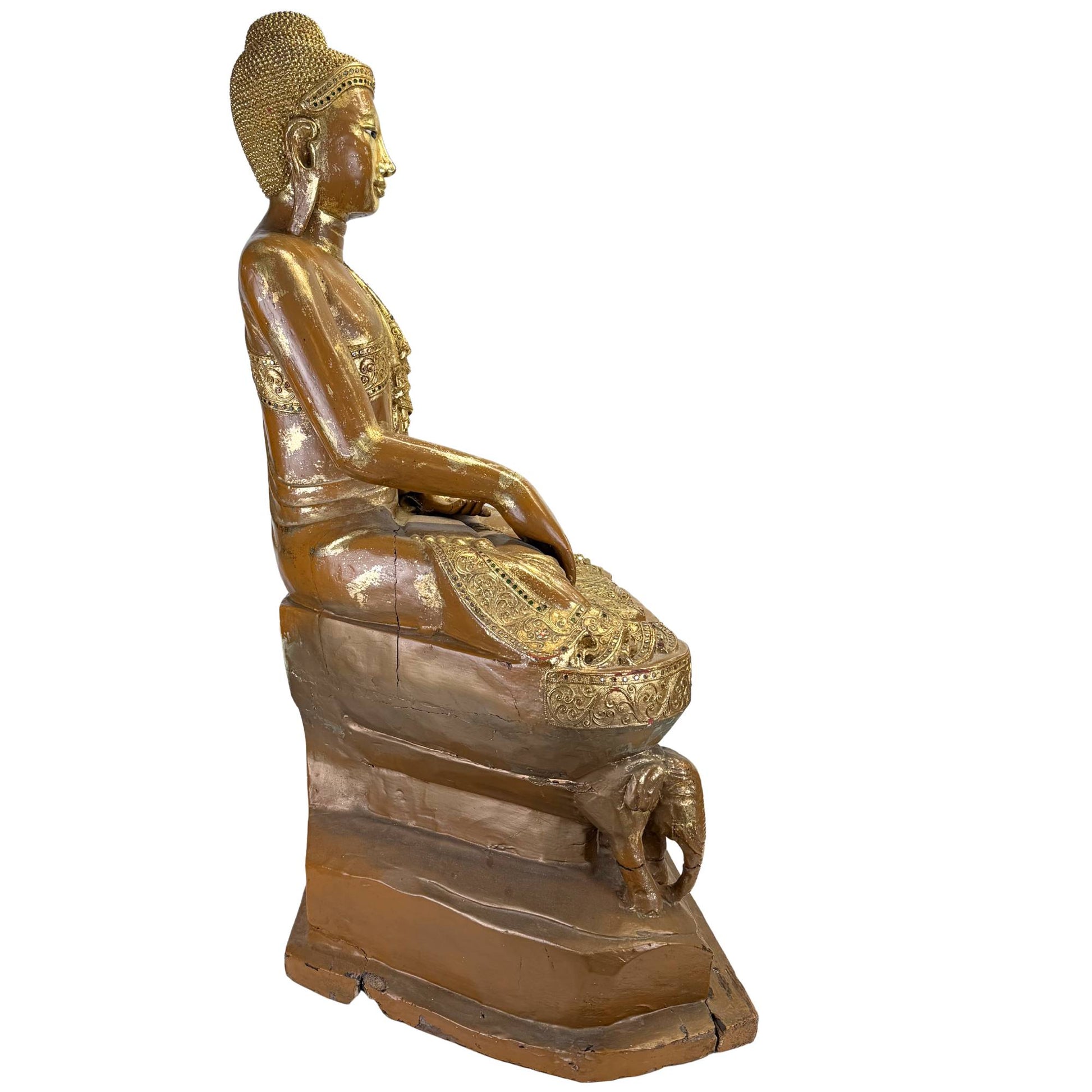 Side view of antique Burmese Buddha on a high throne with elephant detail, gold lacquer, and old drying cracks.