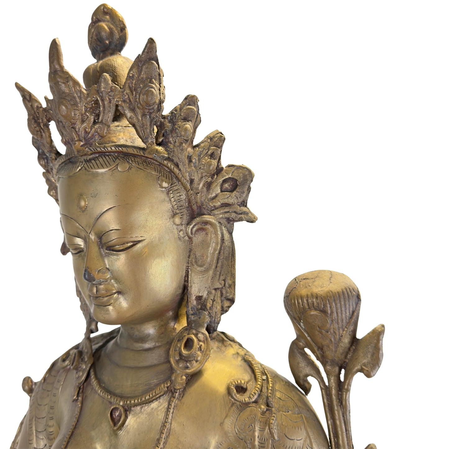 Detail van het serene gezicht, de kroon en de lotusbloem van een antieke vuurvergulde Groene Tara uit Nepal.