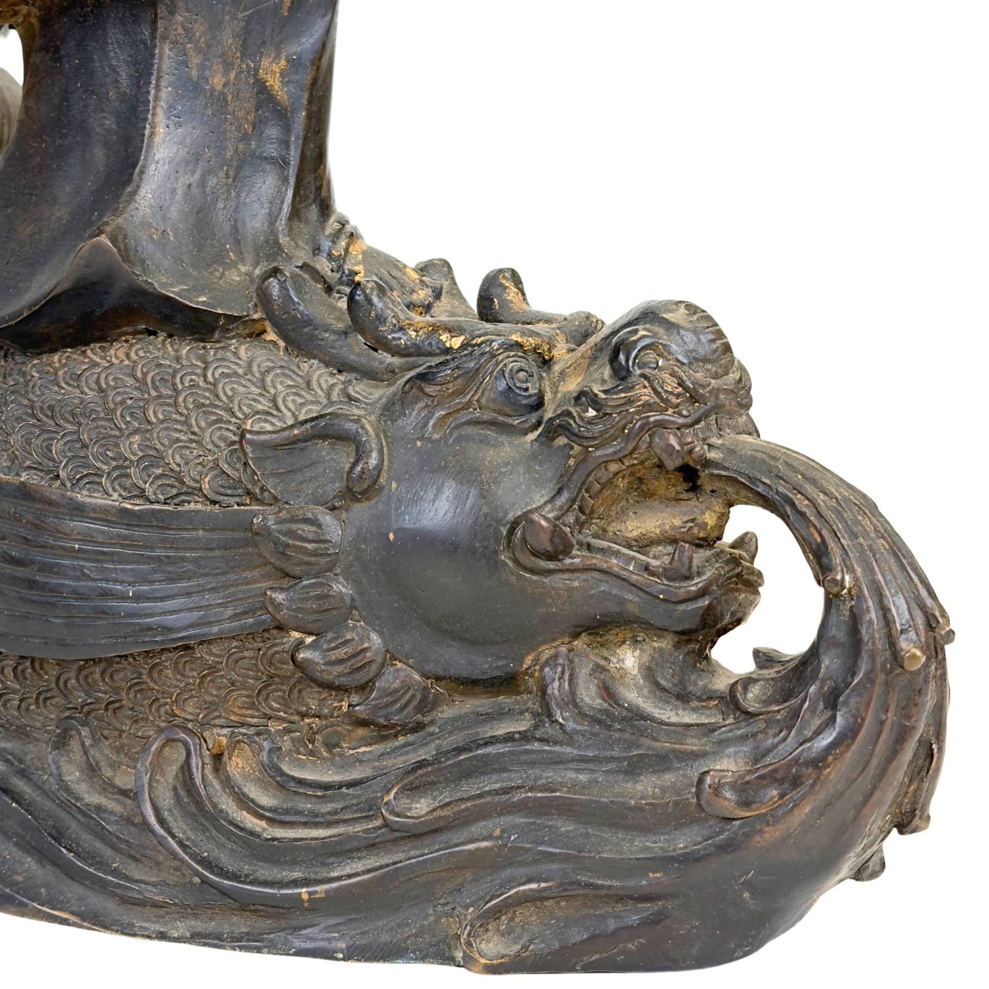 Antique Guanyin on a dragonfish water base, crafted in bronze with a dark patina and remnants of gilding.