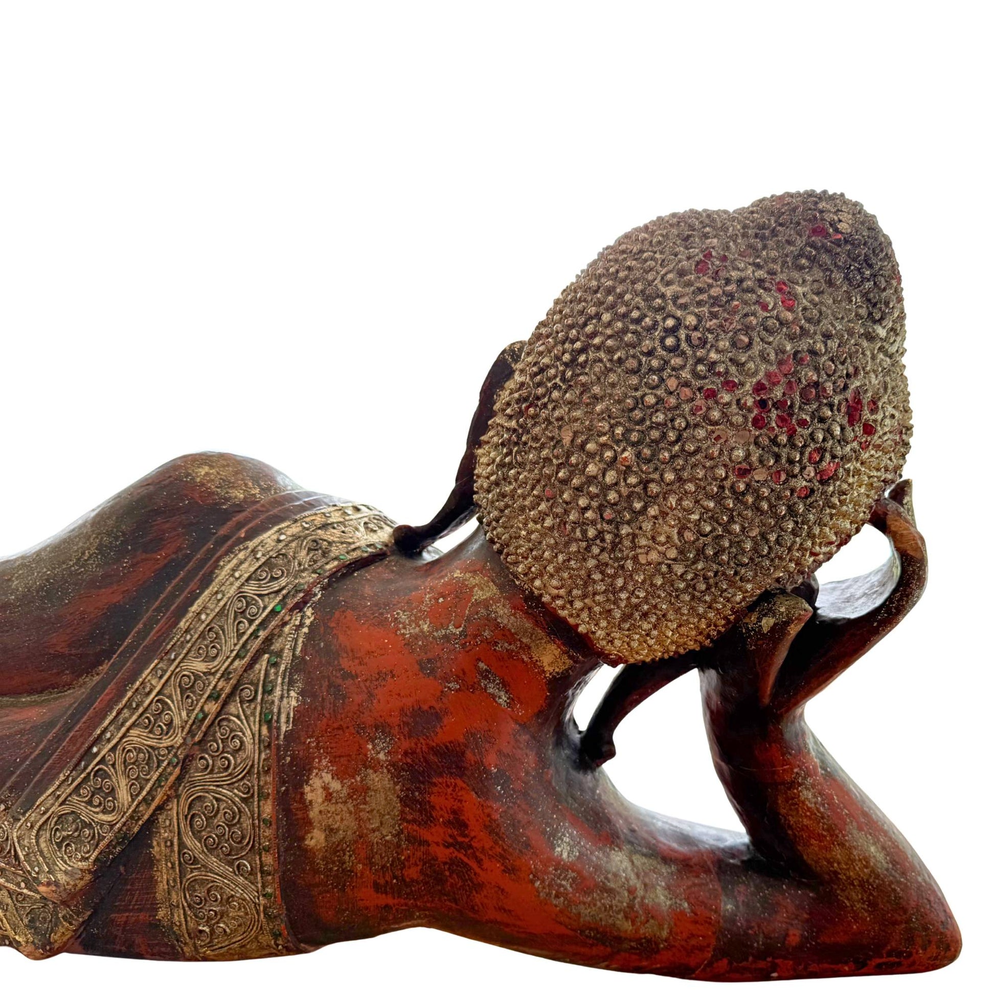 Side view of the hand-carved wooden Burmese Buddha in the specific Tuesday pose