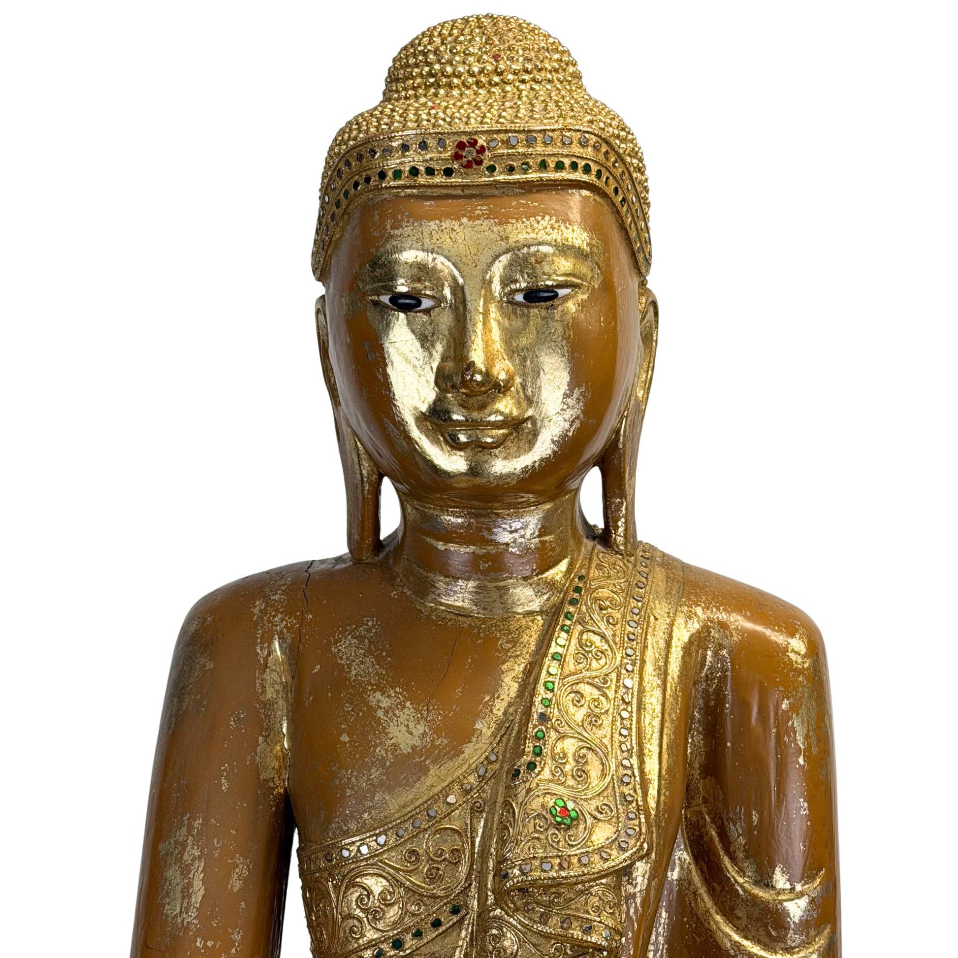 Golden robe of an antique Burmese Buddha with hand-carved floral ornaments and colored gemstones