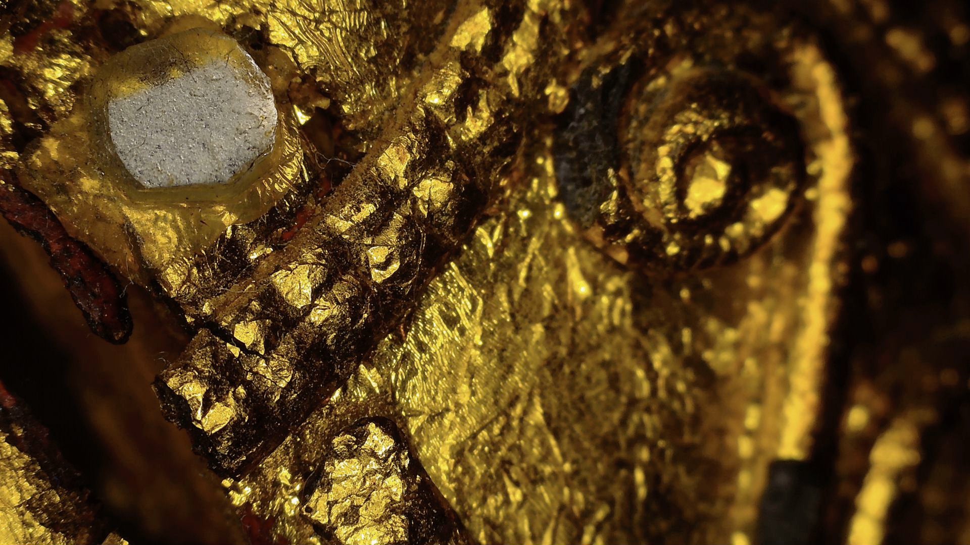 Microscope detail of faceted mirror glass within the gilded decoration
