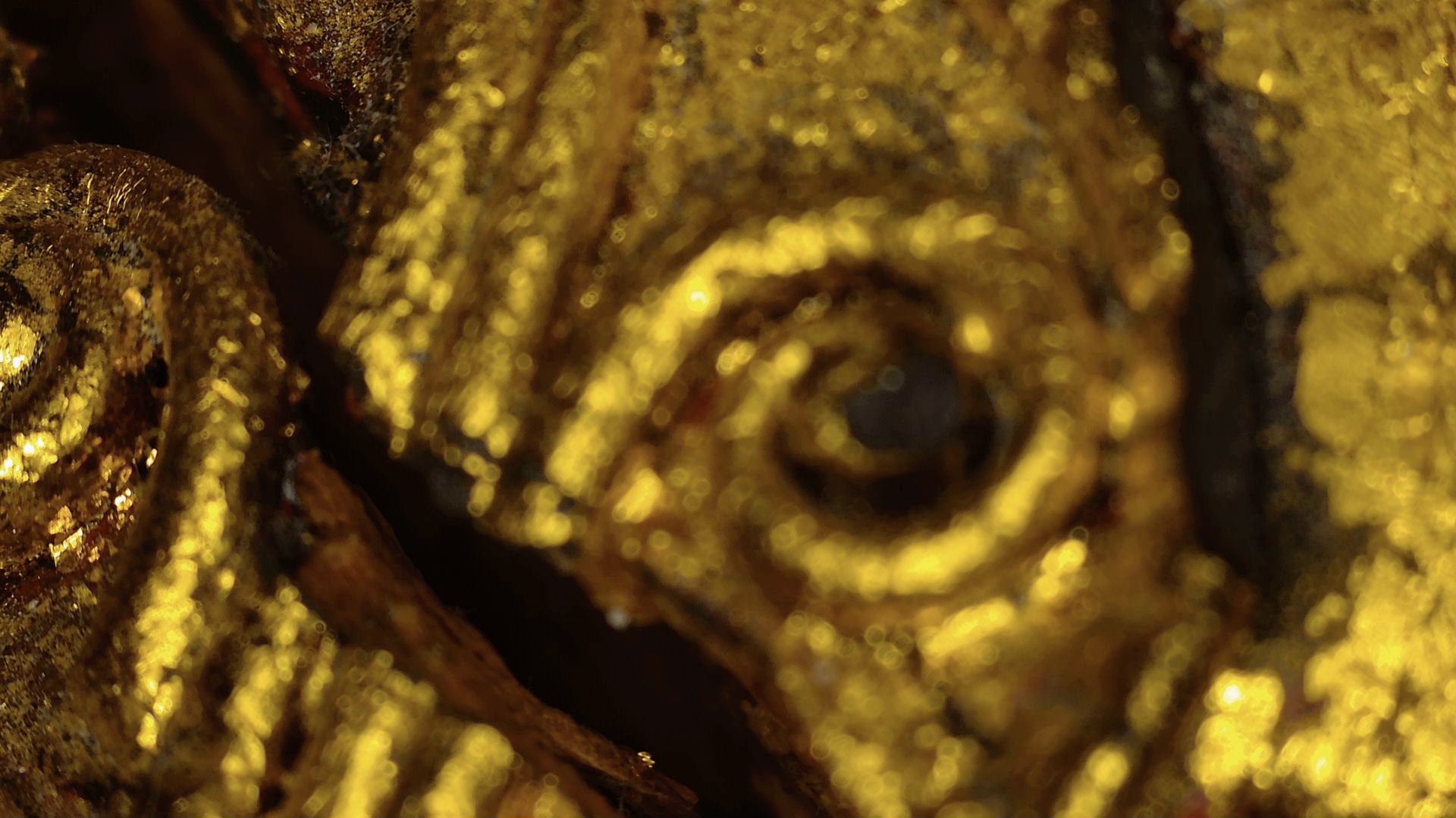 Microscope detail of old gilded relief on the Burmese Buddha sculpture