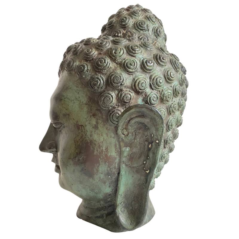 Buddha head with closed eyes made of bronze