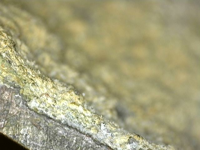 Microscopic view of cuprite and dark oxidation on antique Brahma statue