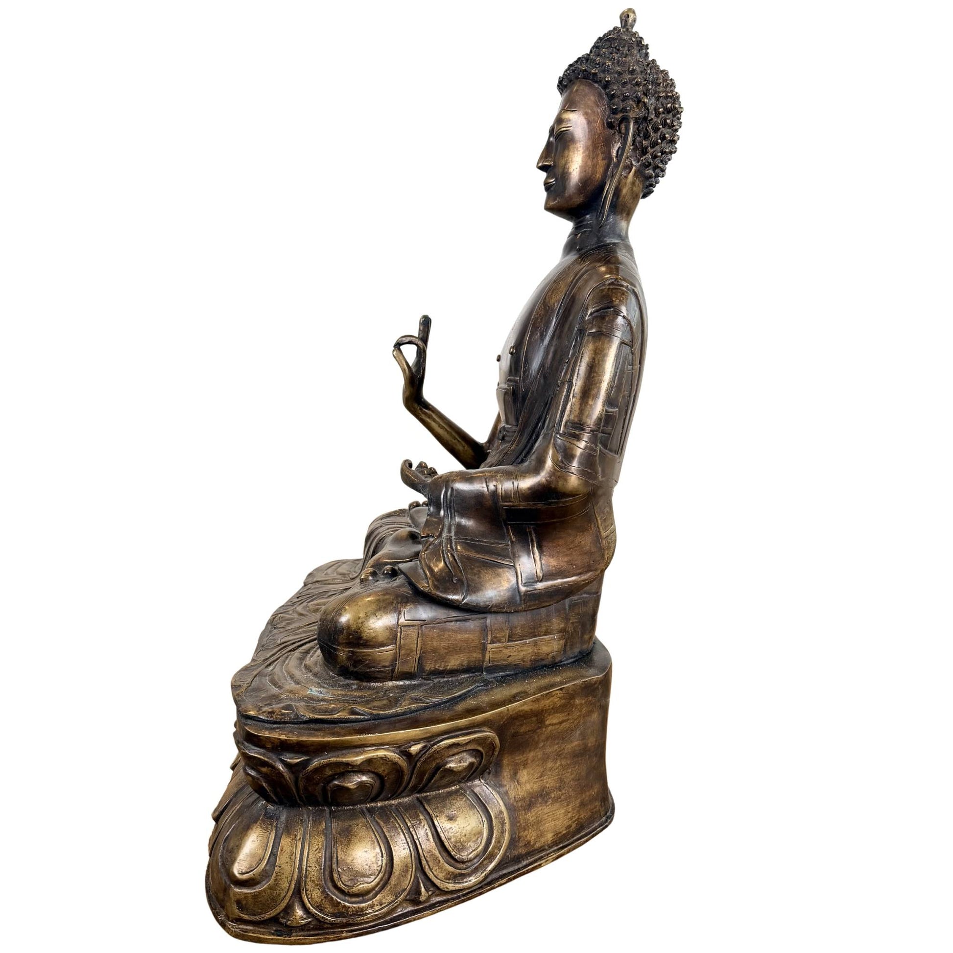 Detail of bronze Buddha with serene facial expression and refined mudra