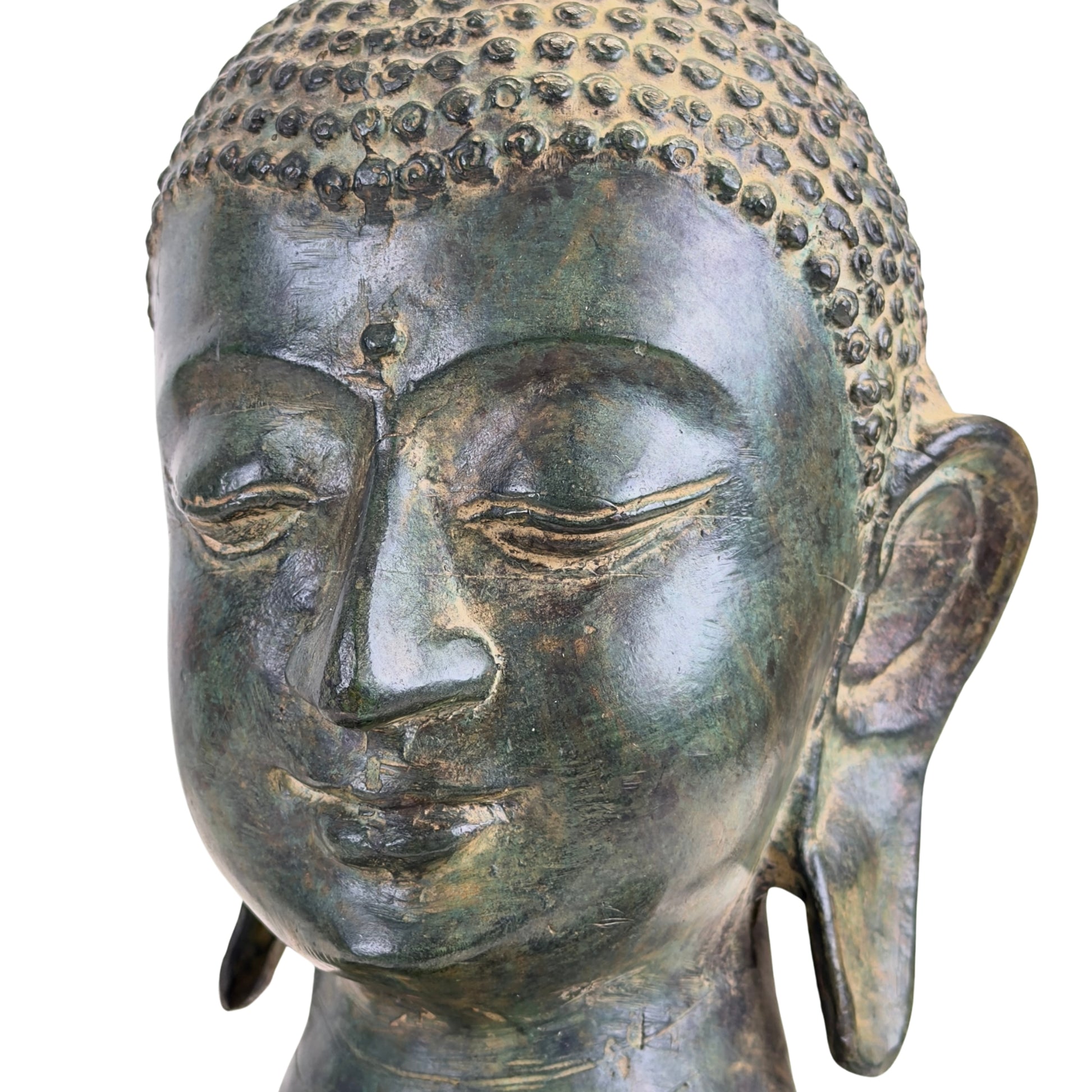 Detail van de linkerzijde van het gezicht van een bronzen Boeddhabuste uit Thailand.
