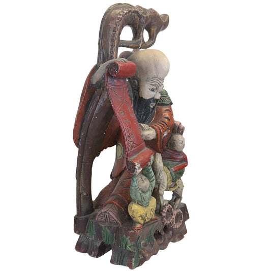 Vue de trois quarts avant de la sculpture Shoulao, montrant la sculpture sur bois taillée à la main et la sculpture détaillée des figures qui l'accompagnent.