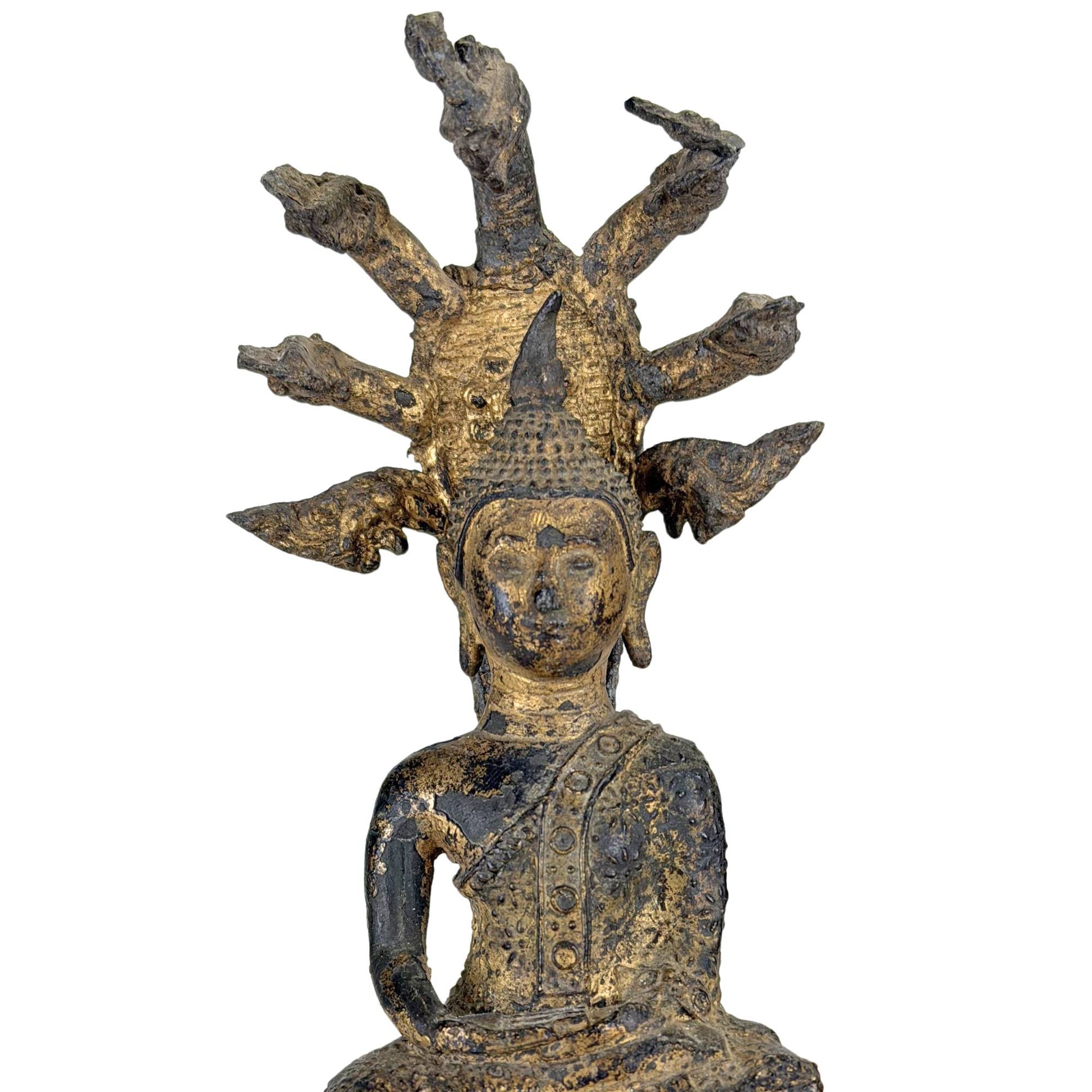 Close-up of antique gilded Thai Naga Buddha with a serene facial expression