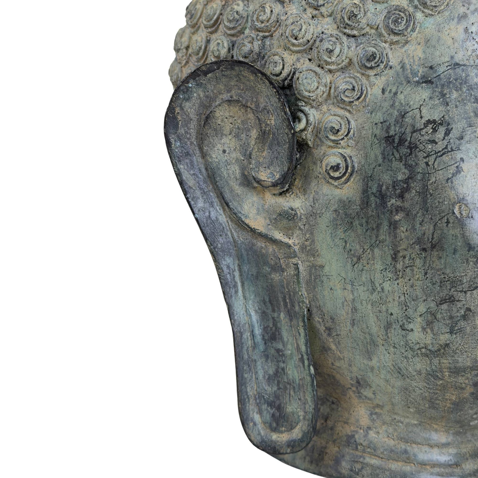 Detail of the long earlobe and patina of the bronze Buddha head