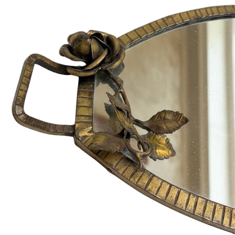 Detail of a bronze coupe dish on three legs from a French table setting
