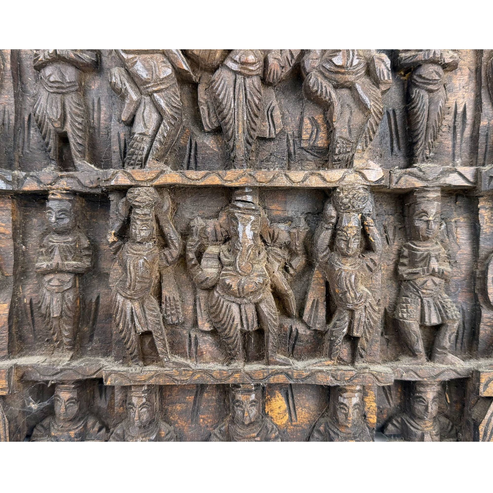 Detailed depiction of the celestial dancers and Hindu deities in the upper register of the ancient temple frieze.