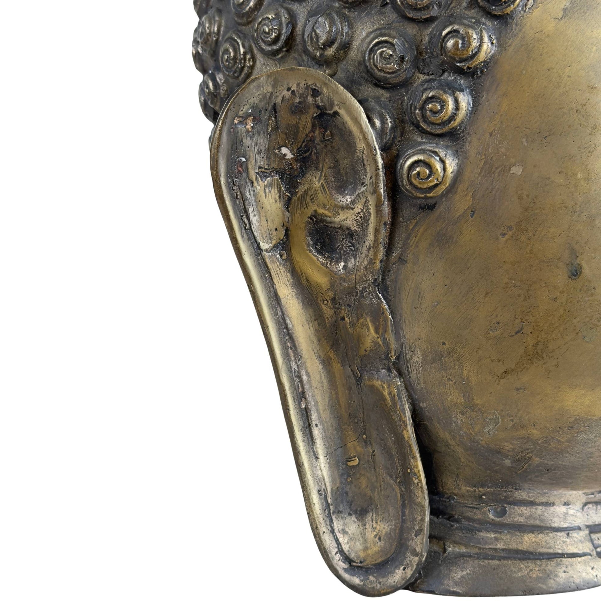 Detail of the long earlobe of a bronze Buddha sculpture