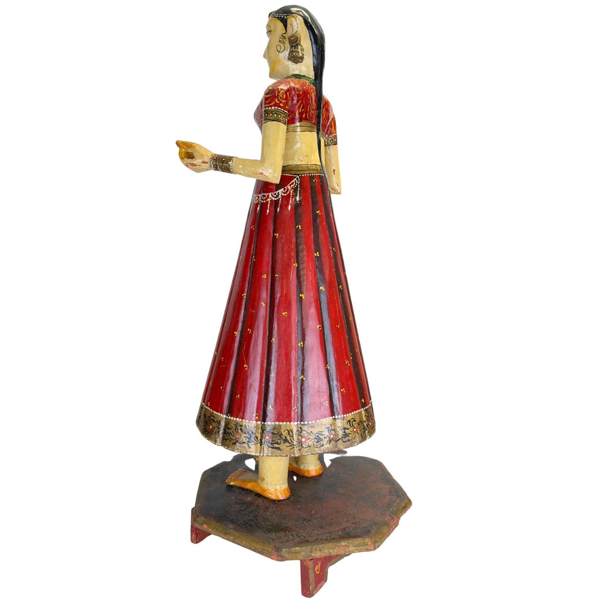 Detail of a Rajasthani bride's face with large almond eyes, red lips, bindi, and black painted hair.