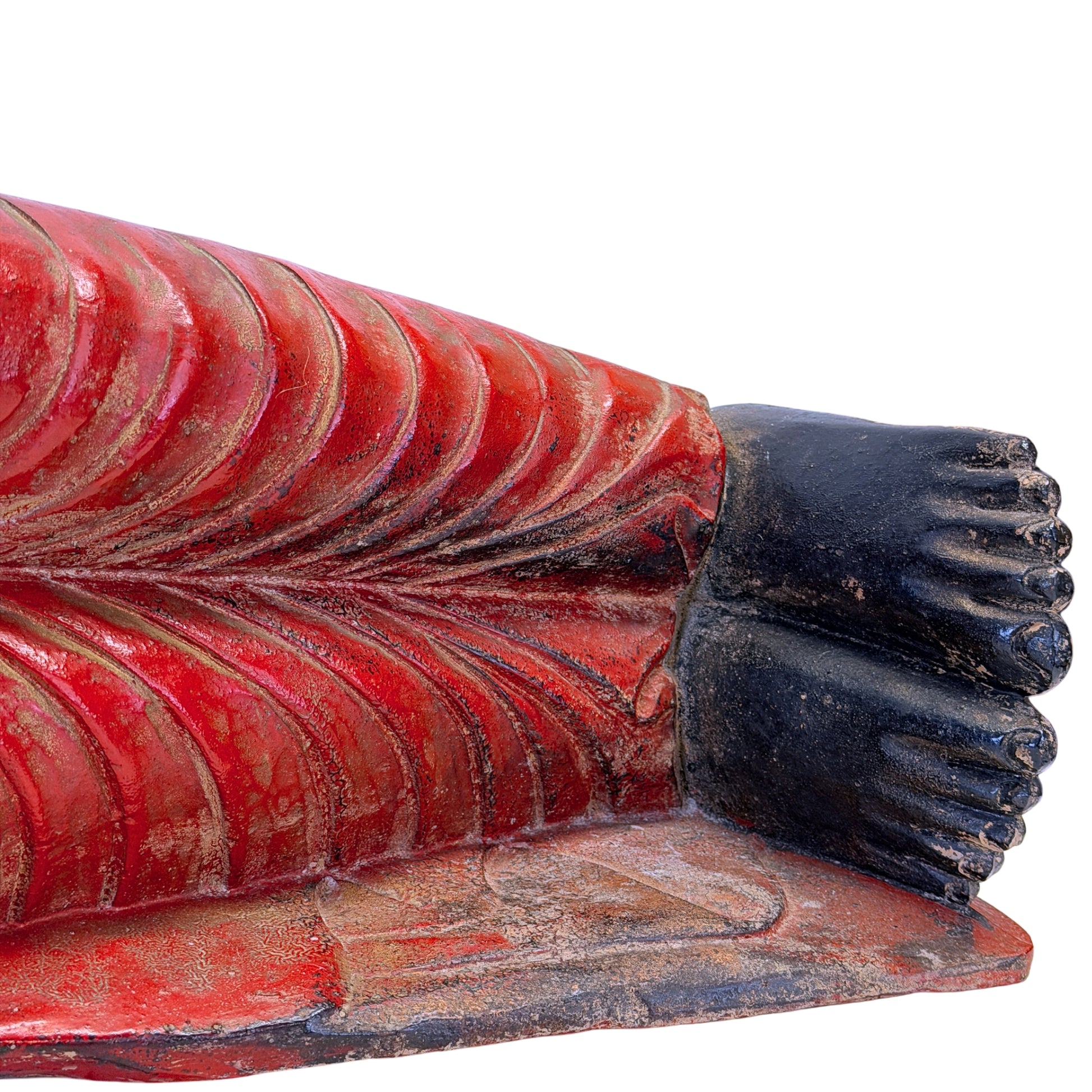 Detail of the feet and red robe of the antique reclining Buddha