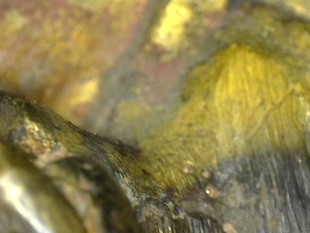 Microscope image of natural surface weathering on antique bronze Ganesha