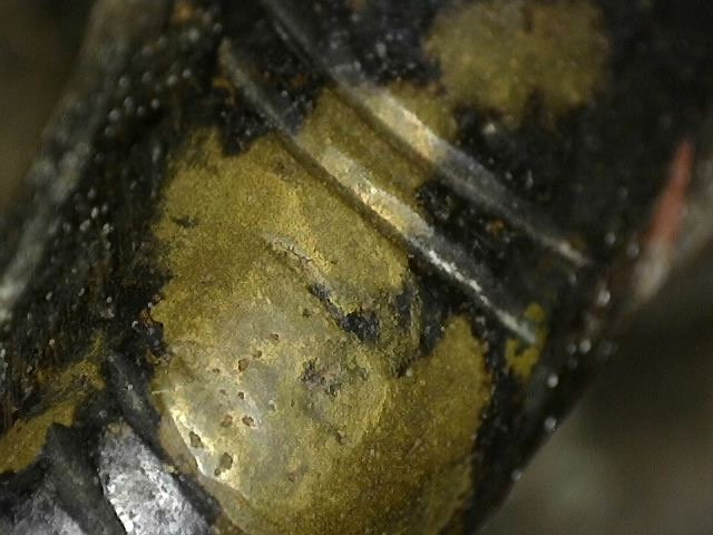 Microscope image of fire gilding residue on an antique bronze Ganesha statue