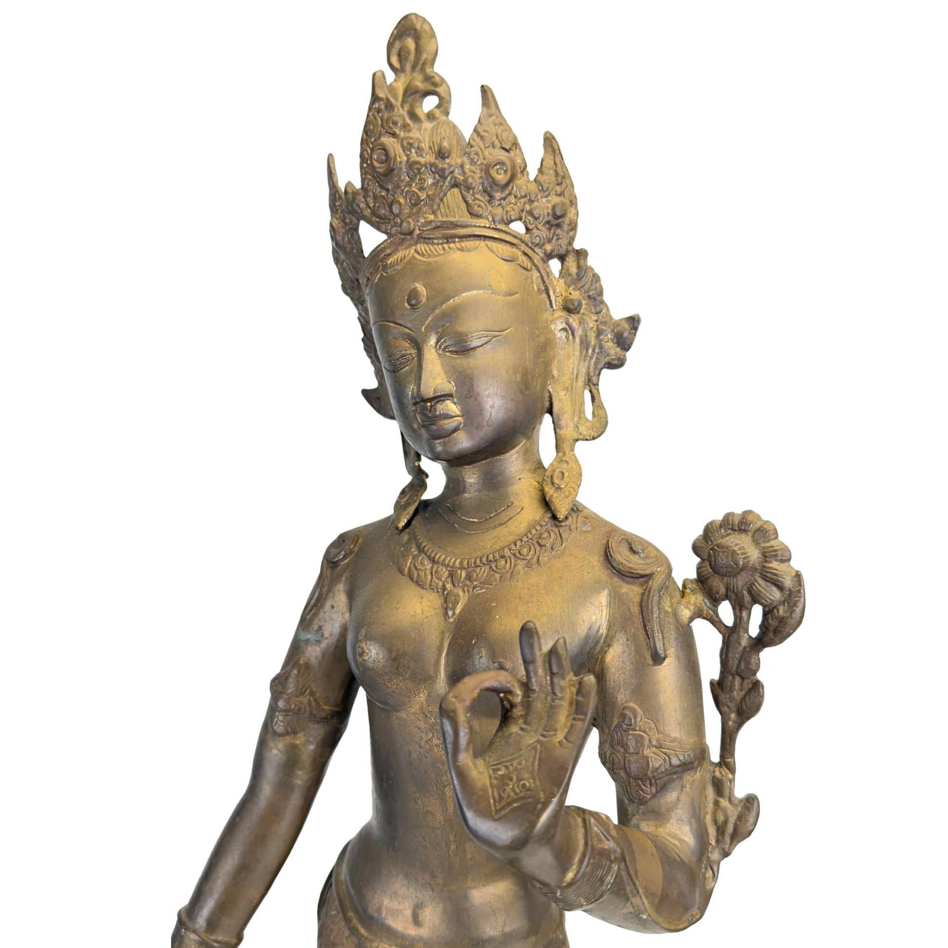 Detail of the serene face of an antique Green Tara with a richly detailed crown.