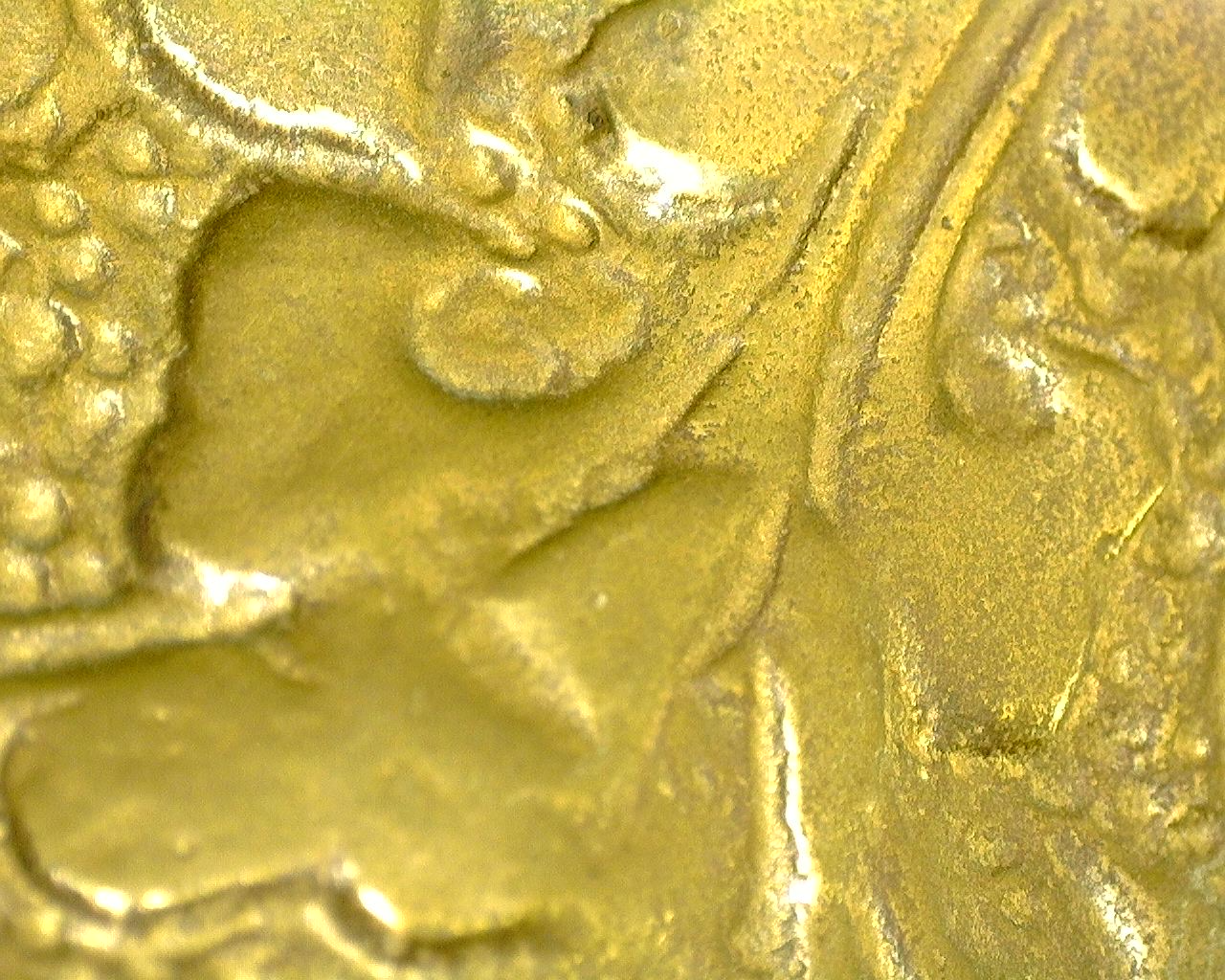 Detail of the hand-engraved dhoti with sharp floral ornaments and natural patina.