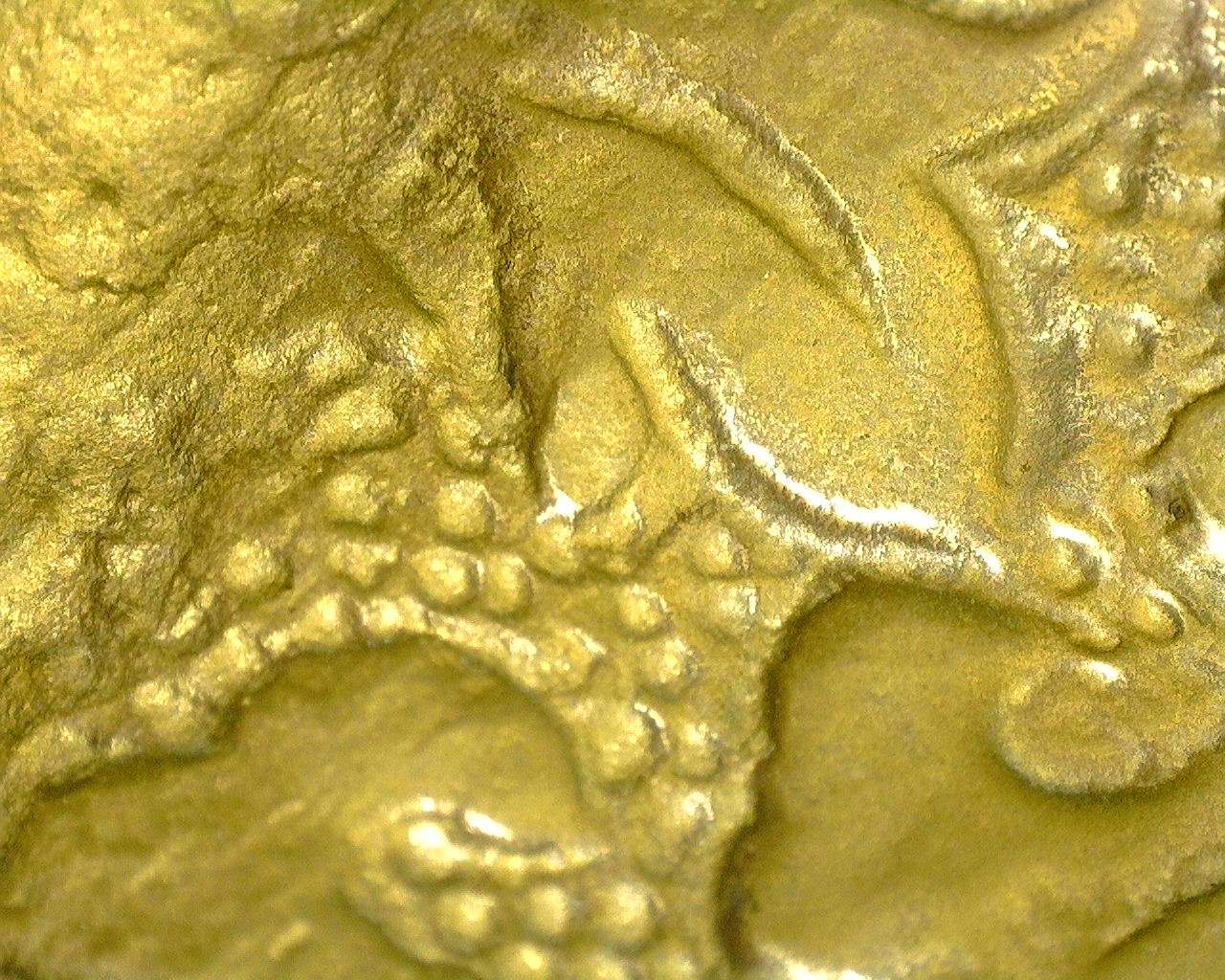 Microscopic image of finely engraved lotus decoration with remnants of original fire gilding.
