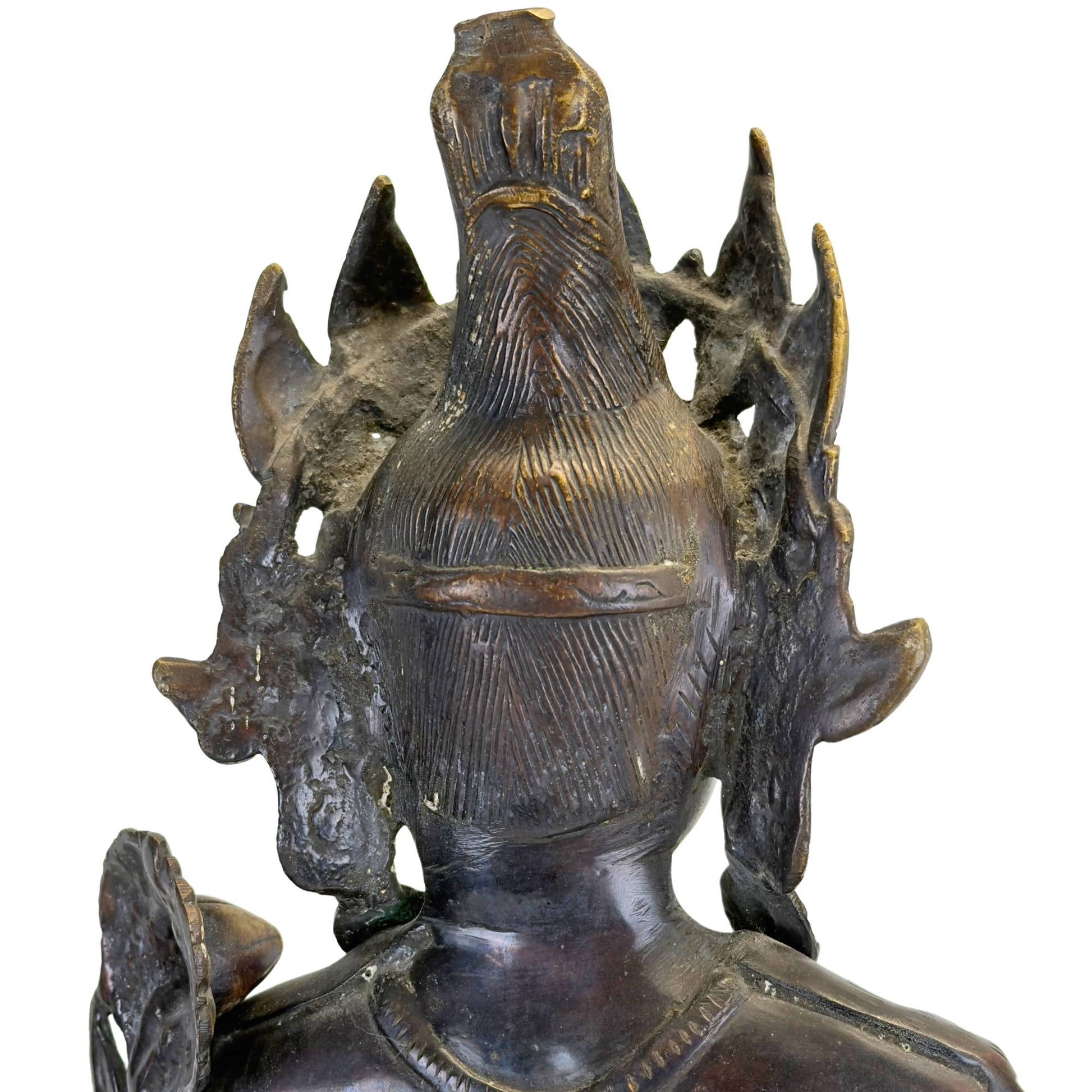 Back of the head of an antique bronze Green Tara from Nepal with engraved hair bun, openwork crown, and black Newar patina.